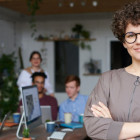 Eine selbstbewusste Unternehmerin steht vor Ihrem Team