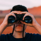 Mann blickt durch ein Fernglas
