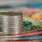 Münzstapel liegt auf Euroscheinen.