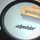 Lupe mit einem Stempel, der das Wort abgelehnt gedruckt hat.