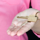 Hand mit einem goldenen Schlüssel.