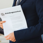 Mann hält ein Dokument in der Hand.
