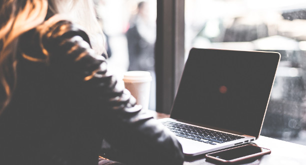 Junge Frau sitzt am Laptop