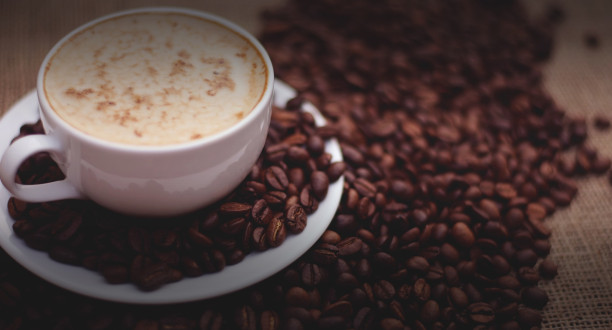 Kaffeebohnen neben einer Tasse Kaffee