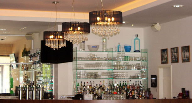 Bar mit Lampen, Gläsern und Getränken