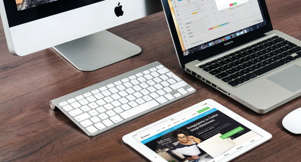 Macbook, Tastatur und Tablet auf einem Tisch