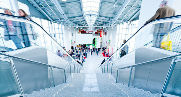 Blick auf eine Rolltreppe mit Personen in einer Messe-Halle