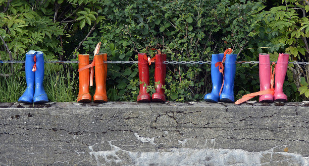 Mehrere Gummistiefel stehen auf einer Mauer