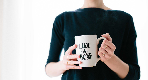 Frau hält eine Tasse mit der Aufschrift: Like a boss