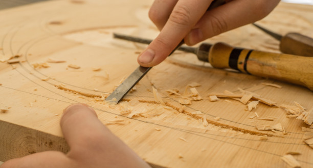 Ein Handwerker schnitzt ein Holzteil