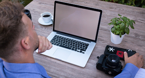 Ein Mann sitzt vor seinem Laptop.