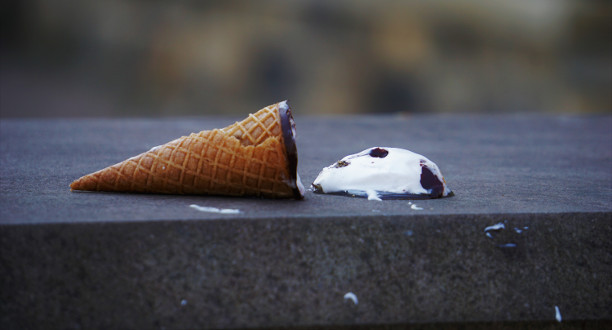 Ein umgefallenes Eis liegt auf einer Mauer.