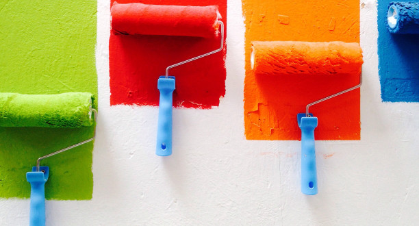 Bunte Farbrollen an der Wand.