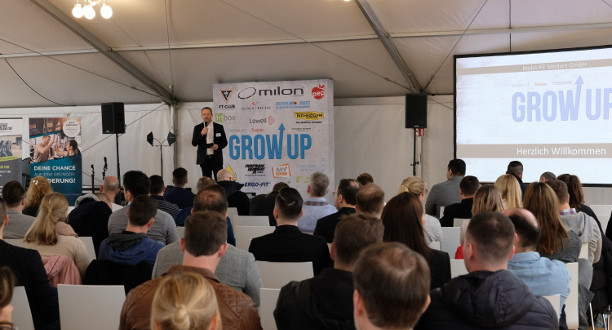 Grow up Boutique-Studio-Kongress – Ein Mann steht vor einer Leinwand und hält eine Rede vor Publikum.