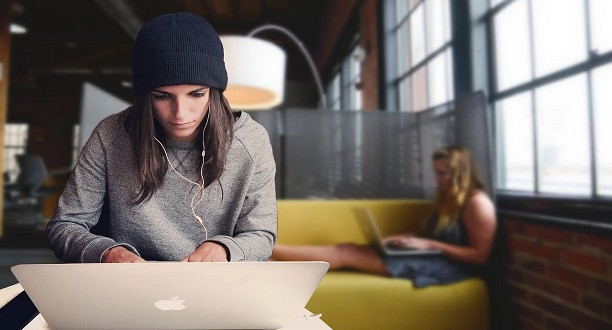 Eine Frau sitzt an ihrem Laptop und arbeitet.