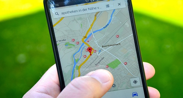 Eine Hand hält ein Handy. Geöffnet ist eine Karte auf Google Maps.