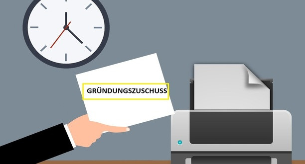 Dokument mit der Beschriftung Gründungszuschuss. Auf der rechten Seite ein Drucker und auf der linken Seite eine Uhr.