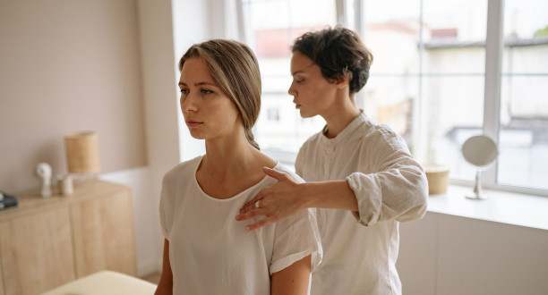 Physiotherapeutin untersucht Patientin.