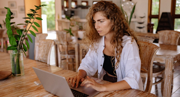 Frau sitzt am Laptop.