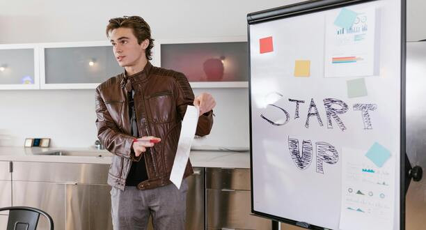 Mann steht vor einem Flipboard, auf dem Start-up steht.