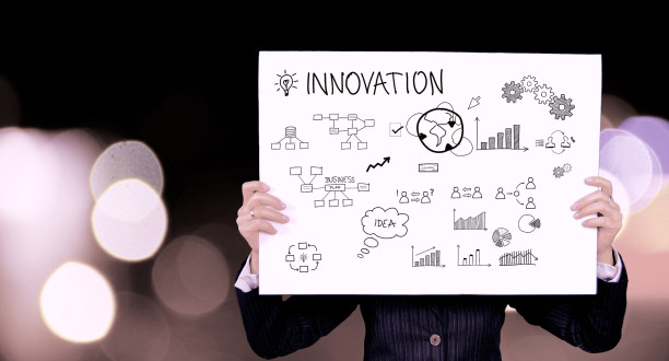 Eine Person hält ein Plakat mit der Aufschrift Innovation in den Händen.