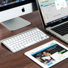 Macbook, Tastatur und Tablet auf einem Tisch