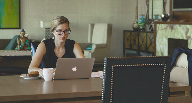Eine Frau sitzt an ihrem Tisch mit einem Laptop