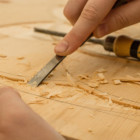 Ein Handwerker schnitzt ein Holzteil