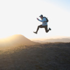 Ein Mann springt über Hügel bei Sonnenuntergang.