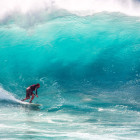 Ein Mann surft auf einer sehr großen Welle.