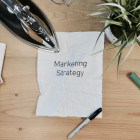 Schreibtisch mit einem Blatt auf dem steht Marketing Strategy