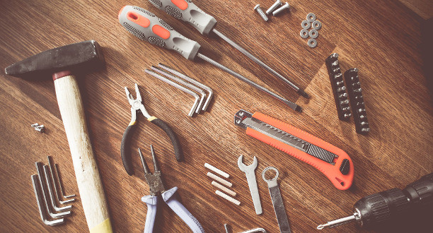 Mehrere Werkzeuge liegen auf einem Holztisch.