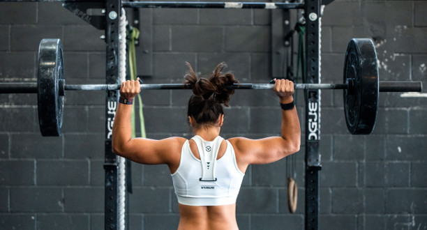 Eine Frau hebt Gewichte in einem Fitnessstudio.