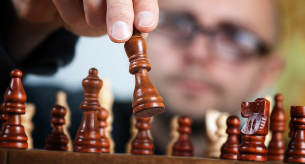Ein Mann spielt eine Schachfigur auf einem Schachbrett.