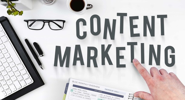 Begriff Content Marketing in schwarzen Buchstaben auf einem Tisch.