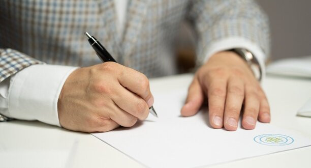 Ein Mann unterschreibt einen Vertrag.