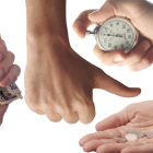Vier Hände halten halten eine Uhr, Münzen und Scheine.