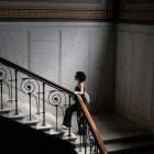 Eine Frau geht die Stufen im Treppenhaus hoch