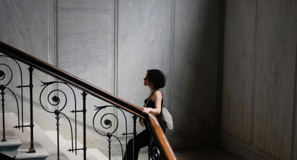 Eine Frau geht die Stufen im Treppenhaus hoch