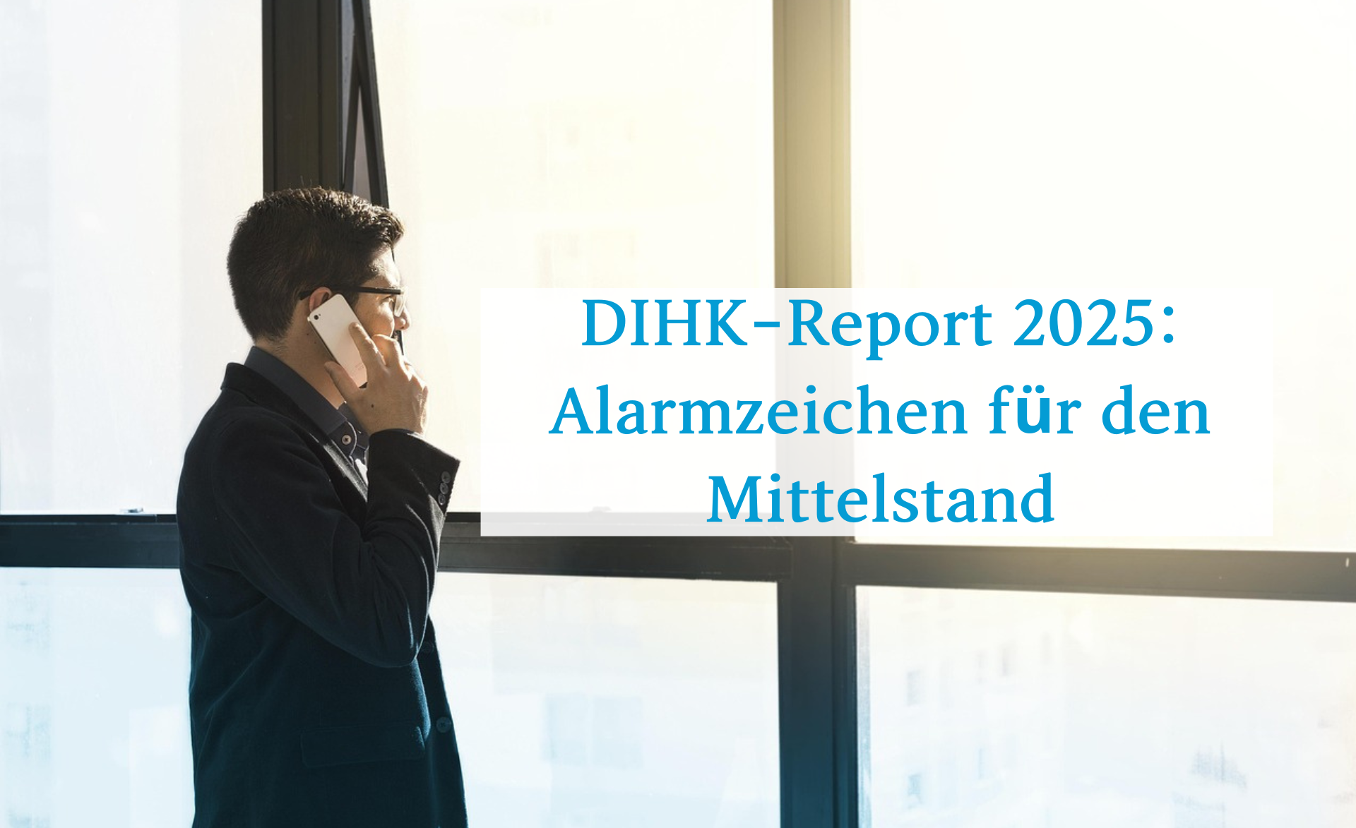 Mann steht mit einem Handy am Ohr am Fenster und telefoniert. Im Vordergrund Schrift: DIHK-Report 2025 Alarmzeichen für den Mittelstand