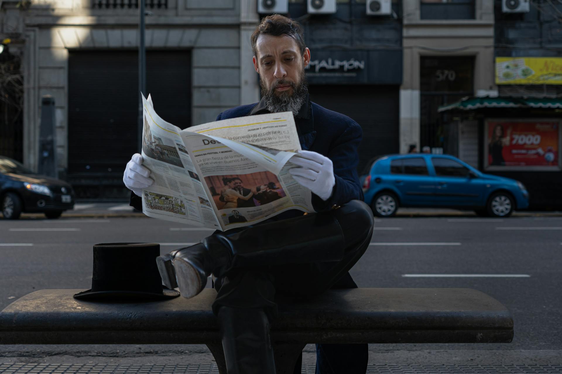 Mann liest Zeitung auf Parkbank.