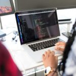 Ein Software-Entwickler betrachtet Code auf einem Notebook.