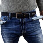 Mann zeigt Hosentaschen, die leer sind, also kein Geld enthalten.