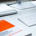 Schreibtisch mit Tastatur und Broschüre zum Thema Brand Identity