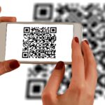 Smartphone mit QR-Code auf Display
