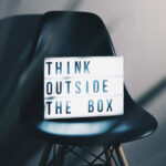 Think outside the Box - Box steht auf einem Stuhl - Geschäftsideen
