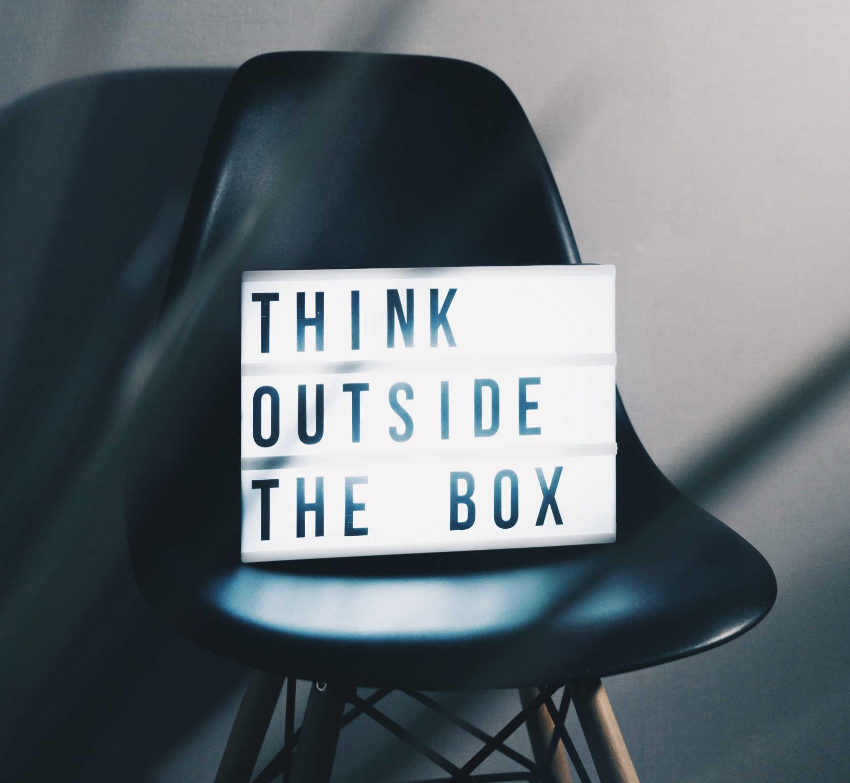 Think outside the Box - Box steht auf einem Stuhl - Geschäftsideen