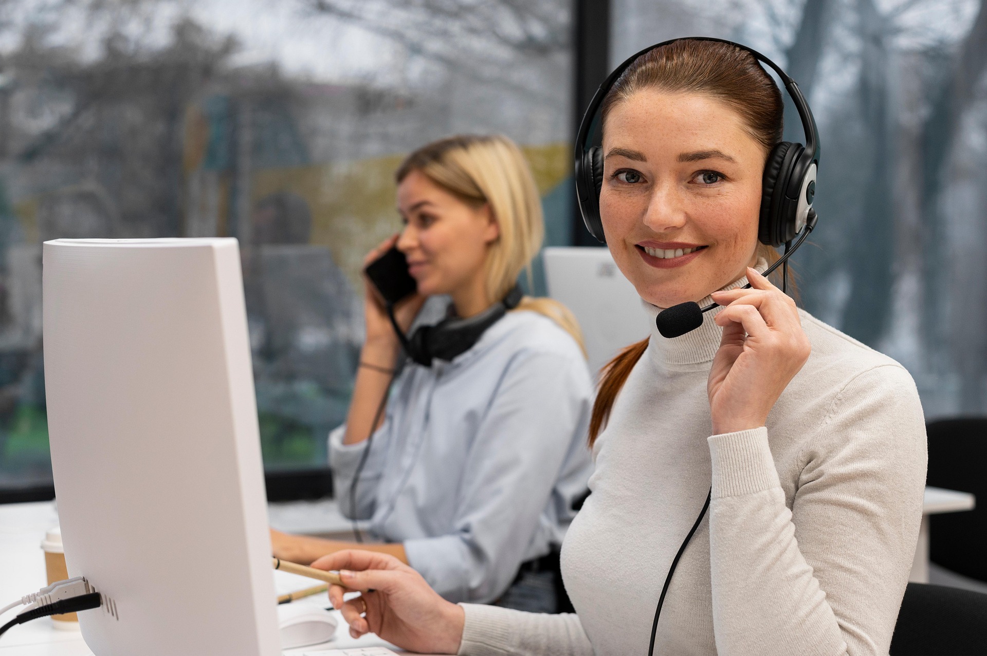 Callcenter mit zwei Frauen, die telefonieren.